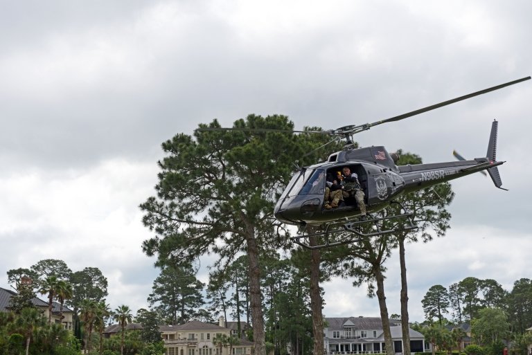 A helicopter flies above the golf course.