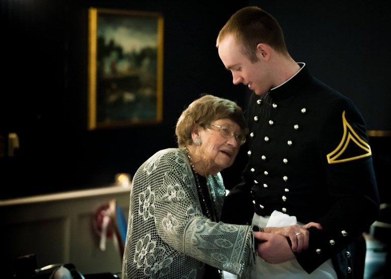 A cadet dances with an elderly woman.