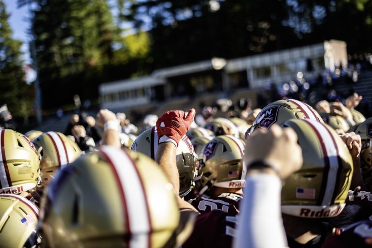 A close-up shot from the rear of cadets rising their fists as they prepare to take Sabine Field.