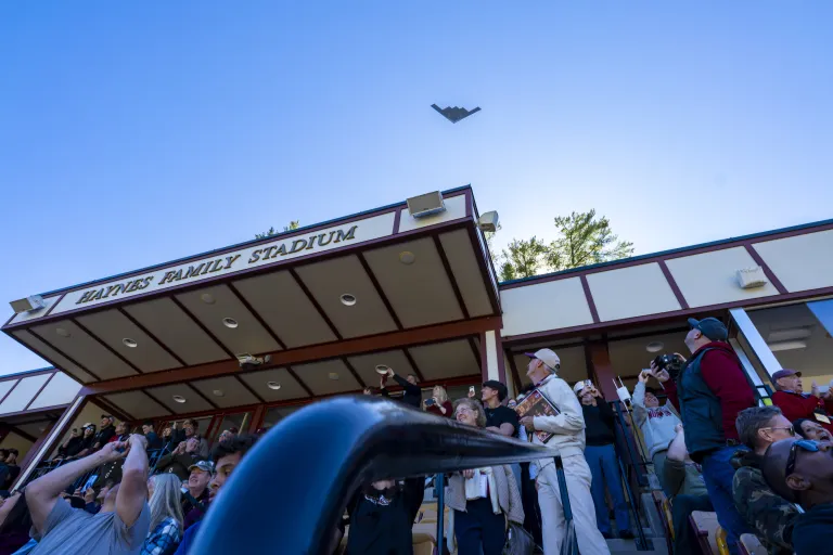 A B-2 Spirit bomber flies over the Norwich University Homecoming crowd