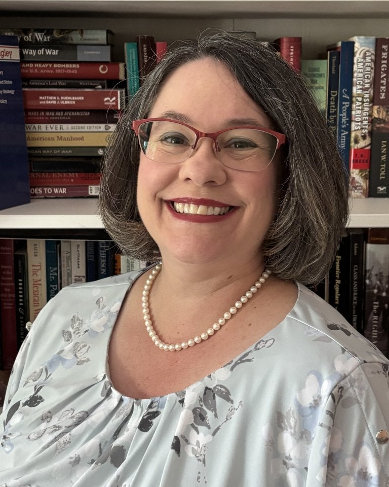 A standard professional headshot of Lisa Mundey in front of a bookcase.
