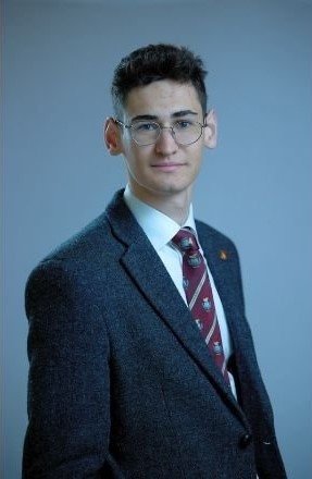 Richard Conlon's formal portrait shot in a suit and tie.