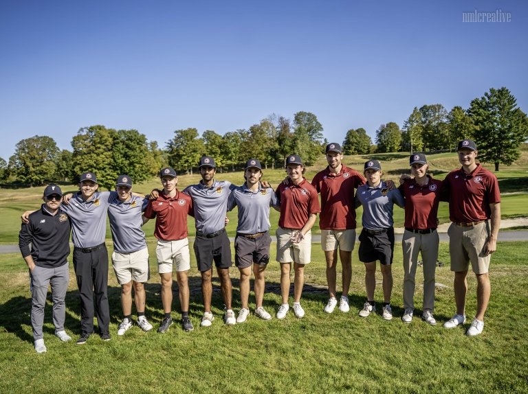 The Norwich men's golfers stand in a line for a group shot on the course.