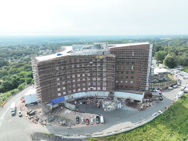 A birds-eye view of a large building being constructed, near completion.