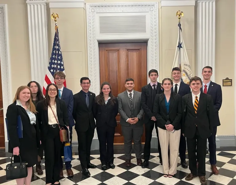 A group of students stand outside of a Congressional office.