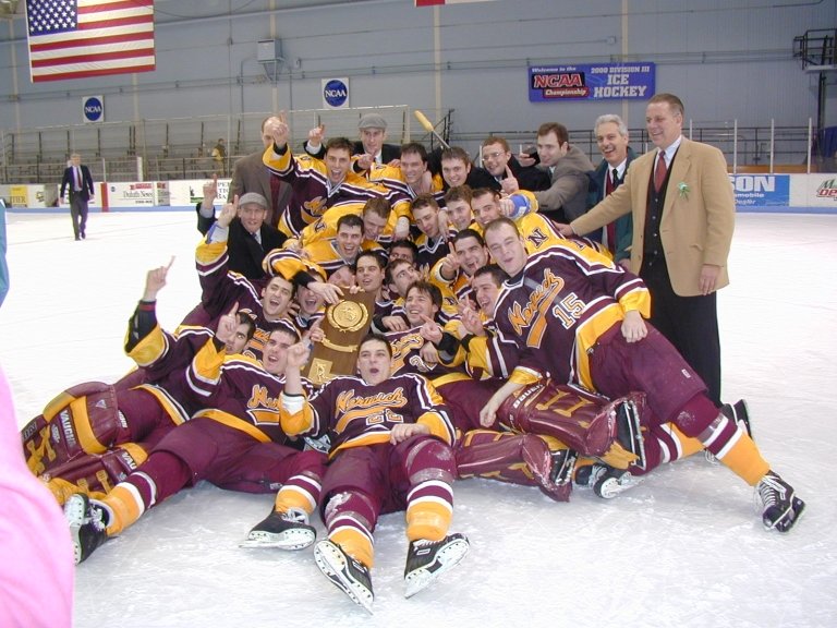 The team celebrates together on the ice, holding the trophy.