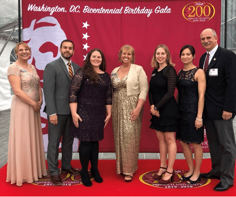 A group stands on the red carpet during a formal Norwich event.
