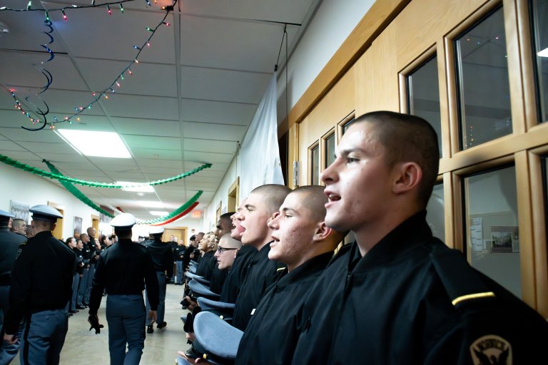 Rooks stand with their backs against the wall in a hallway.