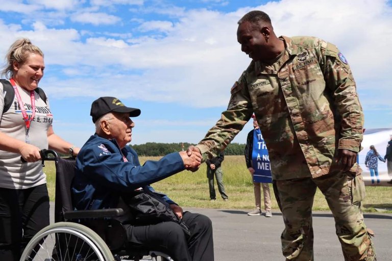 An Army officer in uniform shakes a disabled veteran's hand.
