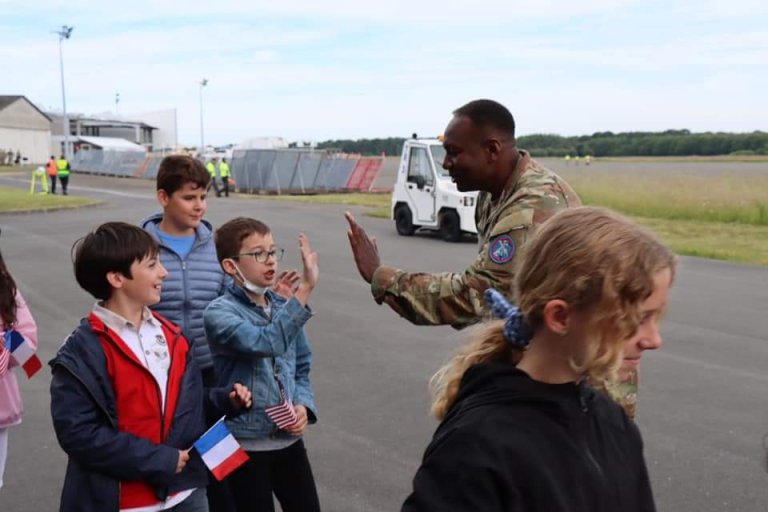 A uniformed Army officer high-fives a young child.