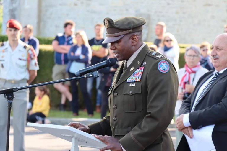 A uniformed officer gives a speech at a podium.