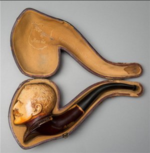 Carved tobacco pipe of a man's head, in a custom pipe case