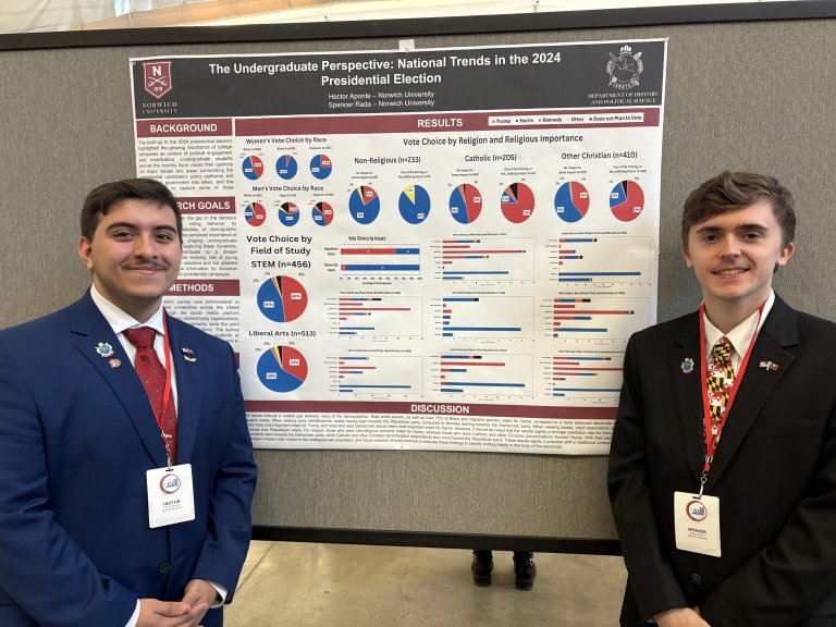 Student stands beside a research poster on the 2024 presidential election.