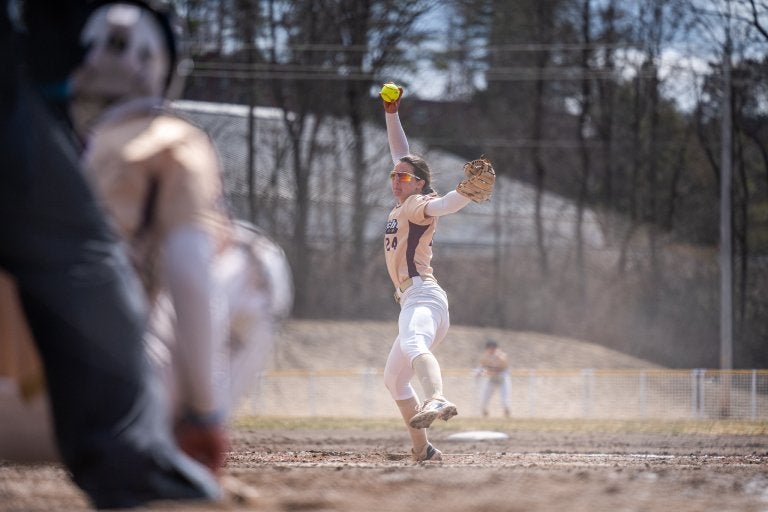Softball pitcher throws a pitch from the mound during a game.