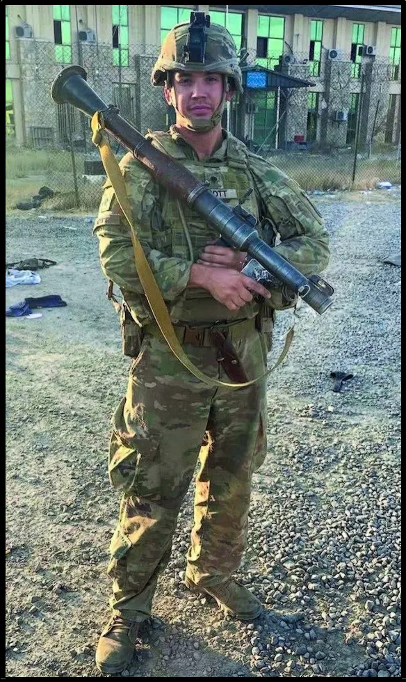A soldier in military fatigues holding a rifle.