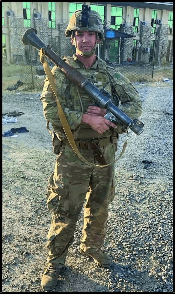 A soldier in military fatigues holding a rifle.