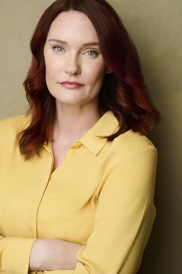 Portrait of a woman in a yellow, button down shirt.
