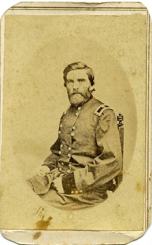 A seated service member in a military uniform poses for a historical portrait.