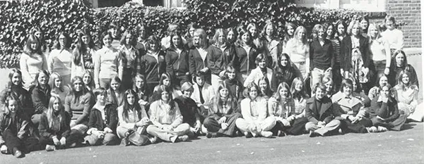 A large group of people pose together outdoors in a black-and-white photograph.