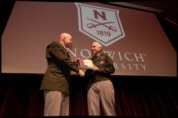 Image on stage with General Paul Nakasone and Norwich University President Mark Anarumo