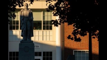 The setting sun briefly illuminates the statue of Alden Partridge that stands in the science building courtyard.