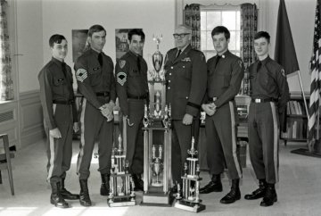 NU President Loring Hart and members of the drill team with trophies, photographed in February or March 1975.