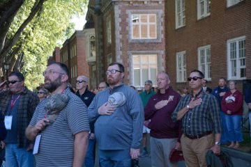 group of men with hands to chest in salute, at 2025 Homecoming Review with Retreat