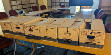 A group of archival boxes on a table.