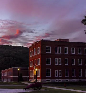Sunset over historic Norwich University buildings with pink and blue skies.