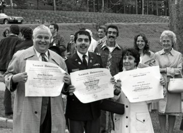 older man, younger man in uniform, woman holding diplomas