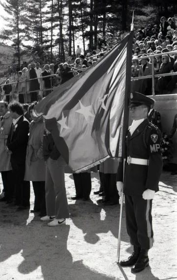 NU cadet in military uniform holding a flag with stars