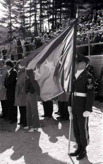 NU cadet in military uniform holding a flag with stars