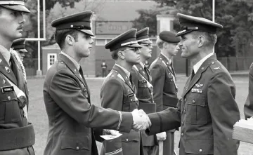 line of Norwich cadets in military uniform, older man shaking hands with second cadet from left
