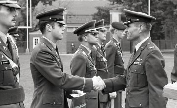 line of Norwich cadets in military uniform, older man shaking hands with second cadet from left