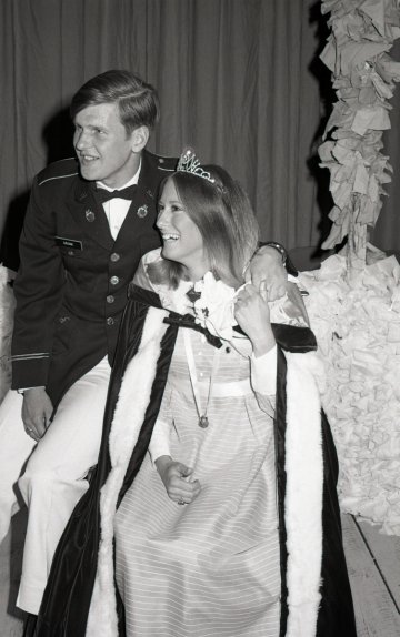 woman in formal dress and tiara with man in uniform