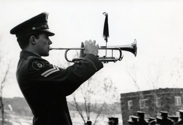 man in military uniform playing a bugle