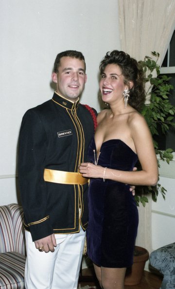 cadet in uniform stands next to his date in dress