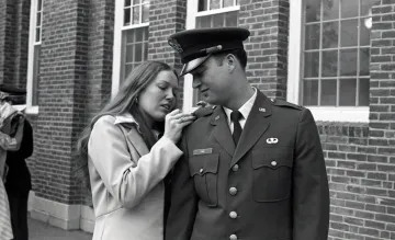 young woman at shoulder of cadet in uniform