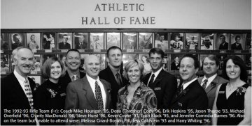 a group of men and women stand before a wall with many photographs with sign above reading "ATHLETIC HALL OF FAME". Group photo of the 1992-93 Rifle Team being inducted into the Norwich Univ. Athletic Hall of Fame. Included in the photo: Dena (Thresher) Cody, Michael Overfield, Stephen Hurst (all '96) and Jennifer Corindia Barnes ('97).