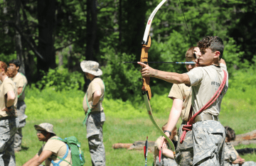 FLC attendee learning archery outdoors.