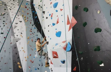 FLC camper climbing the rock climbing wall.