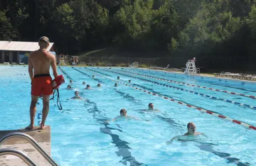 FLC campers swimming outside in a local pool as part of water survival skills training.