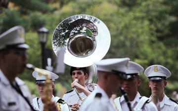 a tuba player is surrounded by several Norwich cadets in formal uniform. Photo from Norwich's 2010 Homecoming.