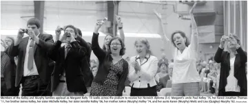 Jennifer L. Kelley '06 is in mid-photo, holding up a flip phone.