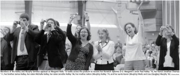 Jennifer L. Kelley '06 is in mid-photo, holding up a flip phone.