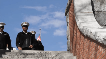 three Norwich cadets in formal uniform and wearing caps approach a stairwell, heading down. Video still from " Spring: Norwich embraces the warm weather"