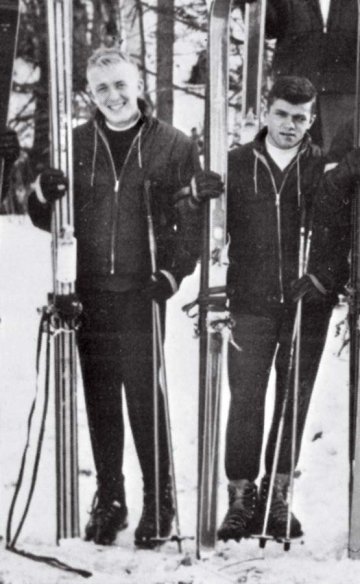 Two men in winter clothing stand holding their skis to their right: John D. Woods and Patrick J. Cunningham
