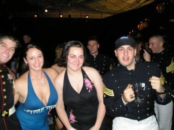 Group of individuals pose at a banquet in formal dress and military attire.
