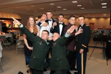 A group indoors in a banquet room in formal attire.