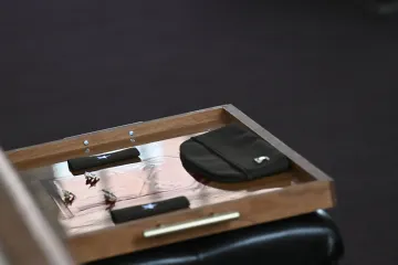 Military insignia and rank items are arranged on a wooden tray.